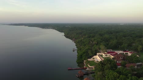 Vista-Aérea-De-Mansiones-En-La-Selva-Tropical-Por-El-Lago-Bacalar-Laguna,-México