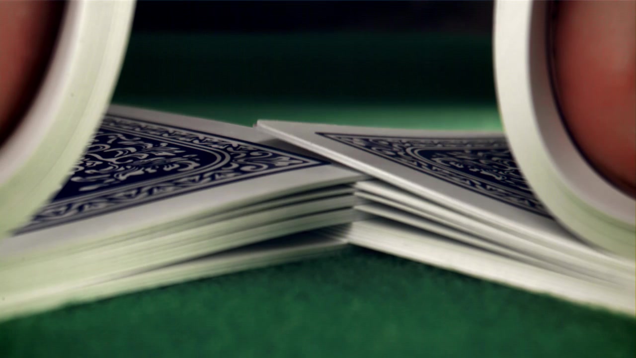 Primo piano di carte da gioco mescolate a riffle su feltro verde