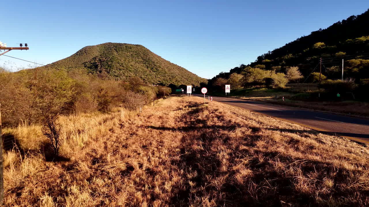 Danger Ahead Road Sign on a Rural Landscape with Mountains