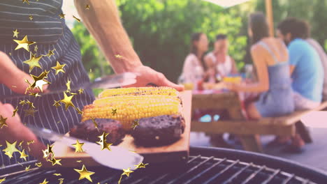 animation of stars over group of caucasian friends having bbq and talking