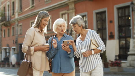 Three-Senior-Female-Friends-Standing-In-City-Center