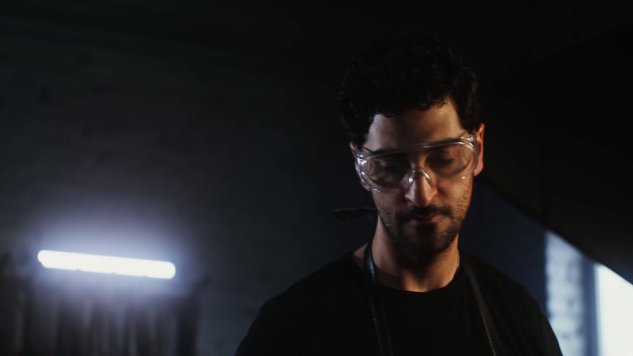 hombre trabajando en un taller oscuro