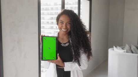 Schöne-Schwarze-Frau-Hält-Tablet-Mit-Grünem-Hintergrund-Und-Lächelt-Vertikal