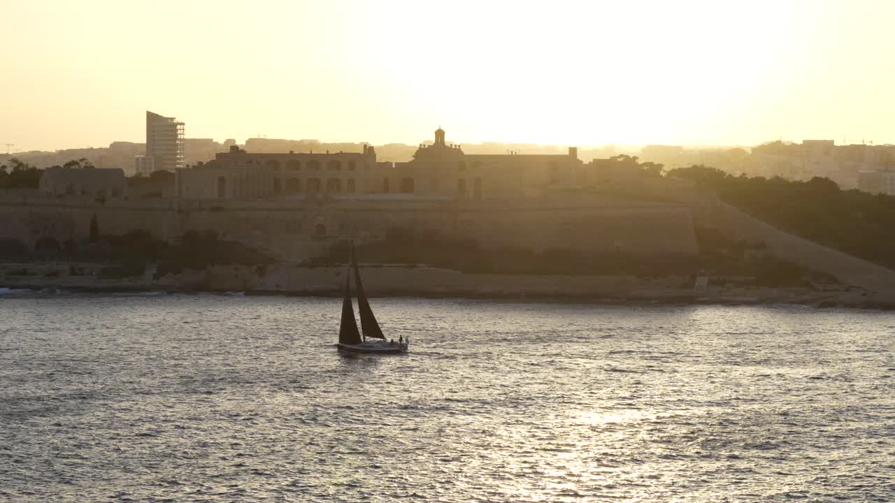 Vacanza in barca a vela a Malta, Mar Mediterraneo. Barca a vela al tramonto al rallentatore