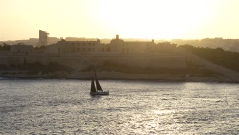 sailing holiday in malta, mediterranean sea. sailboat at sunset in slow motion