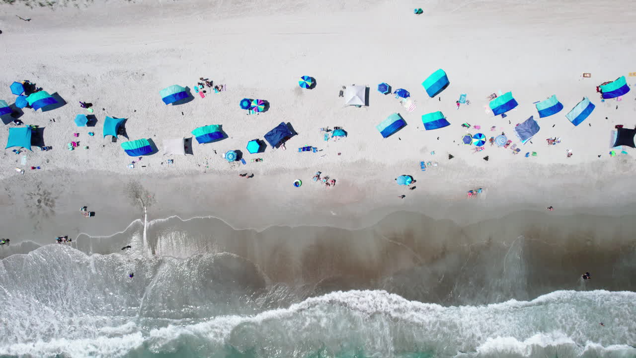 푸르키즈색 바다 물과 해안에 있는 사람들과 함께 해변에서 아름다운 하향 각도 드론 영상