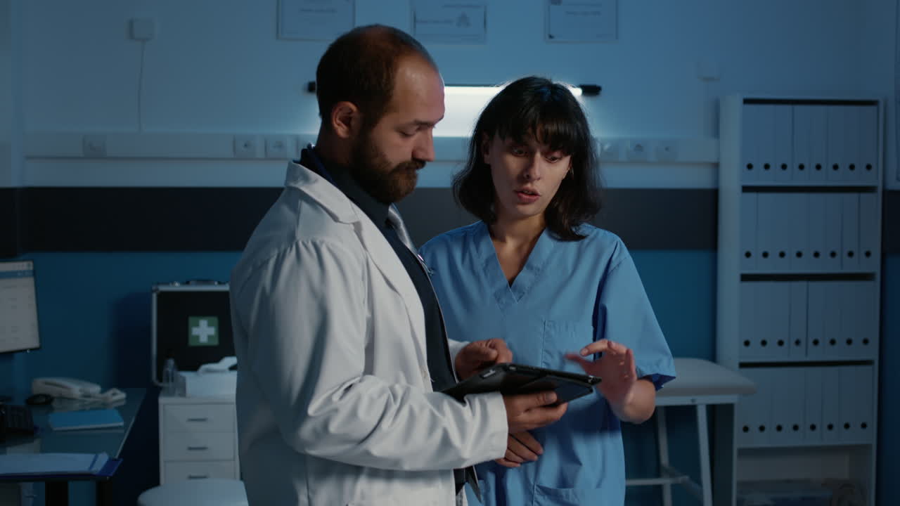 Médico e enfermeira discutindo dados de paciente em tablet