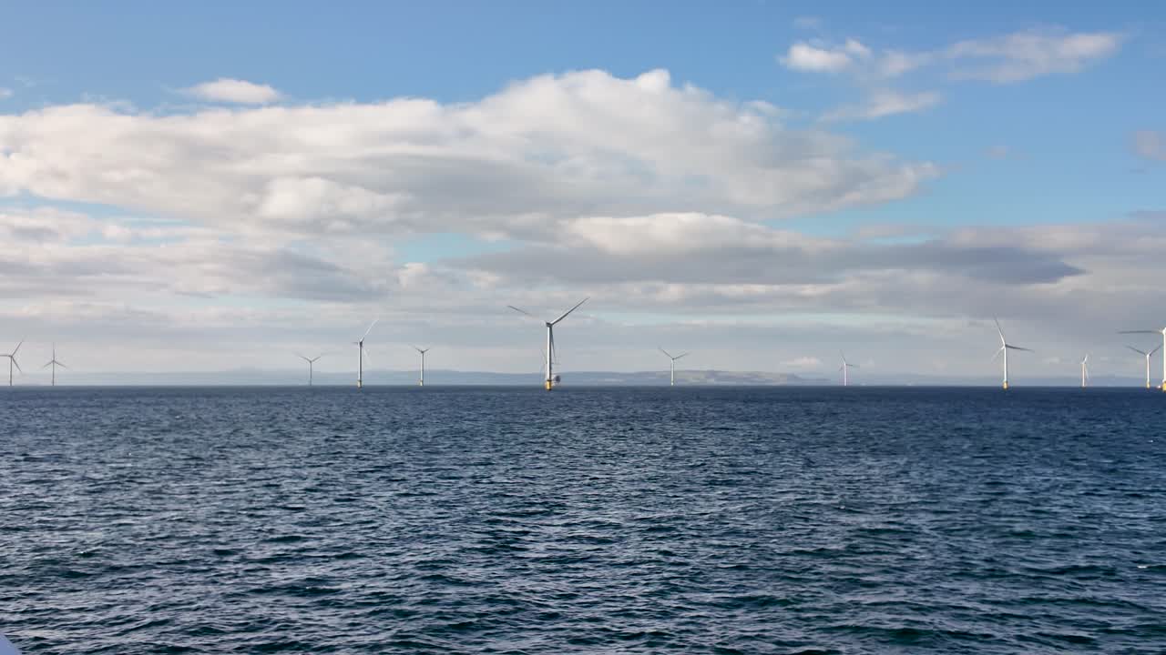 Wind turbines across the Irish Sea create a modern energy landscape over calm, blue waters