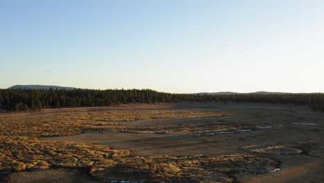 Aerial-flyover-Dry-Lake-Bed-With-Natural-Texture-Of-Cracked-Clay-and-planted-islands-during-sunset