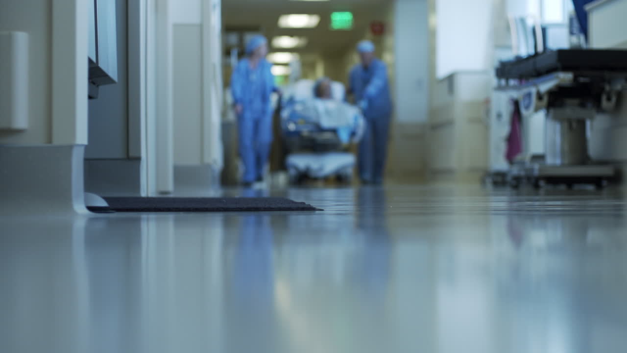 Patient on Gurney Stretcher Being Pushed Through Hospital by Doctors - Slow Motion - 4K UHD
