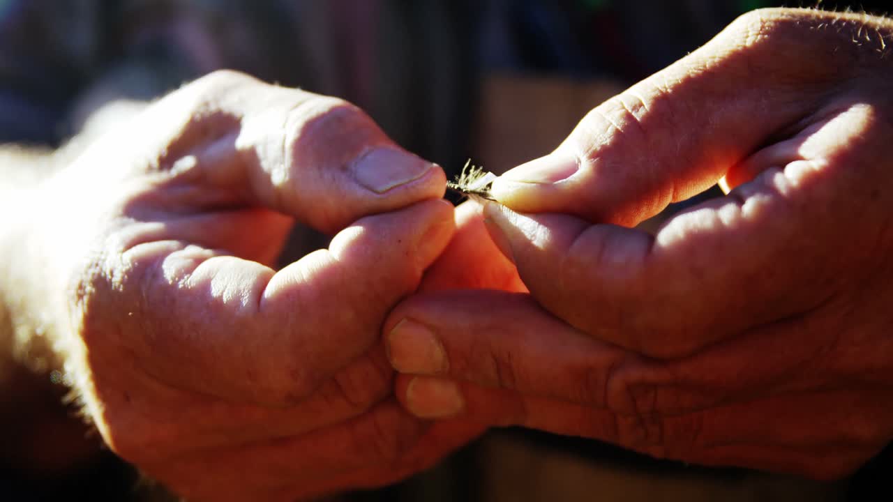 Fly fisherman preparing bait for fishing