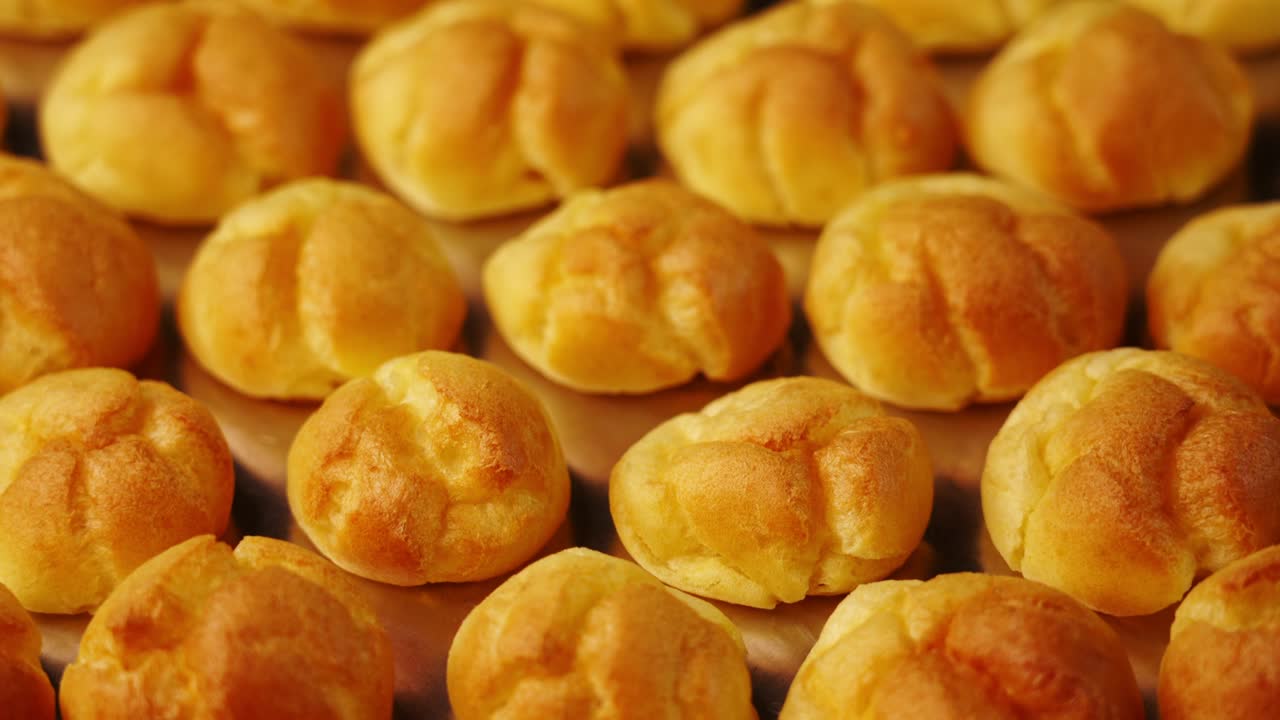 반이는 베이킹 트레이에 맛있는 신선한 에클레어 을 움직입니다.