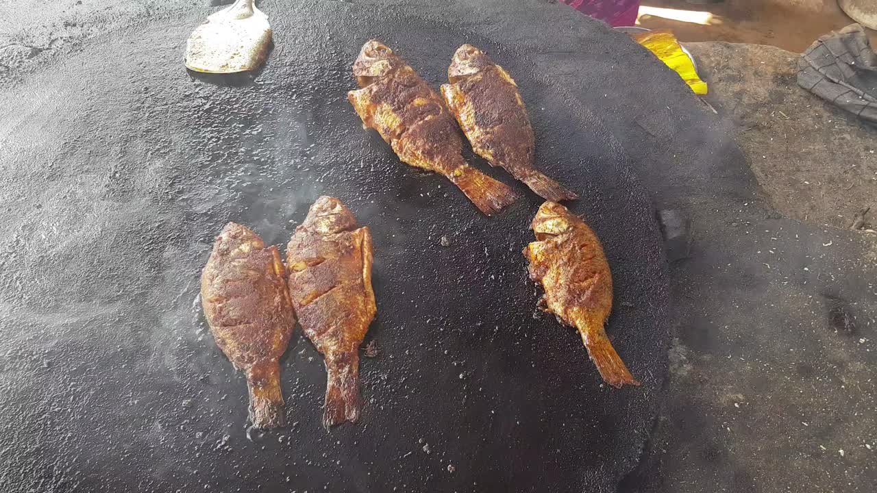 пряная рыба жарится на большой чугунной сковороде