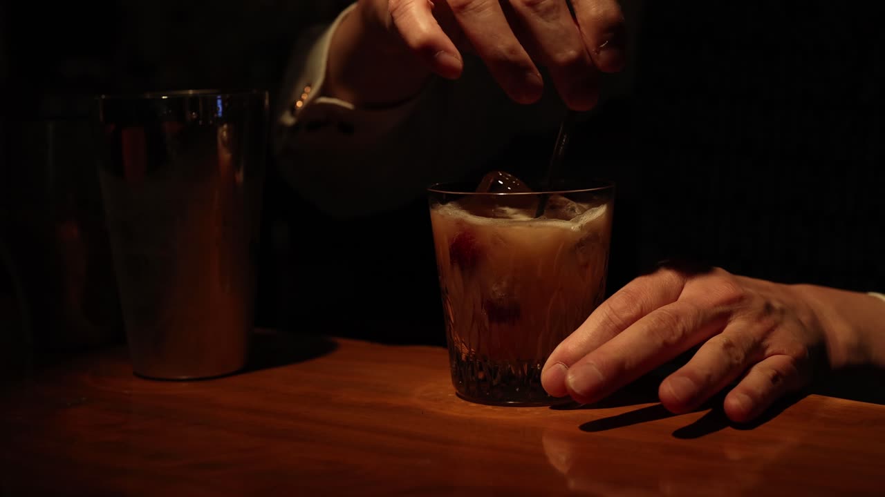 Barman che guarnisce e serve un cocktail