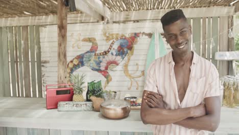 retrato de un feliz dueño de un bar afroamericano, sonriendo en su bar de la playa, cámara lenta