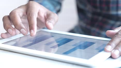 persona que utiliza una tableta con gráficos y gráficos
