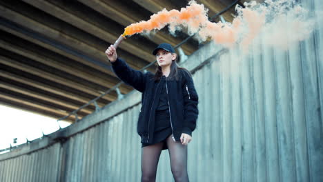 una chica con una bomba de humo en la calle.