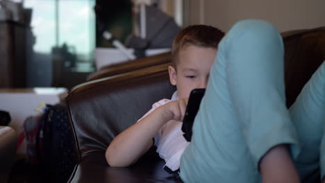 niño con tableta digital relajándose en la sala de espera del aeropuerto