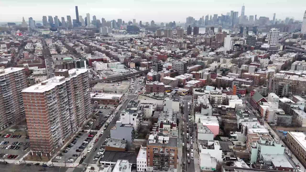 Horizontal drone orbit shot over 11th Avenue in New York, showcasing the city's bustling streets, towering skyscrapers, and iconic Manhattan skyline with smooth circular aerial movement.