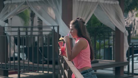 lady puts smartphone in pocket and leans on wooden railing