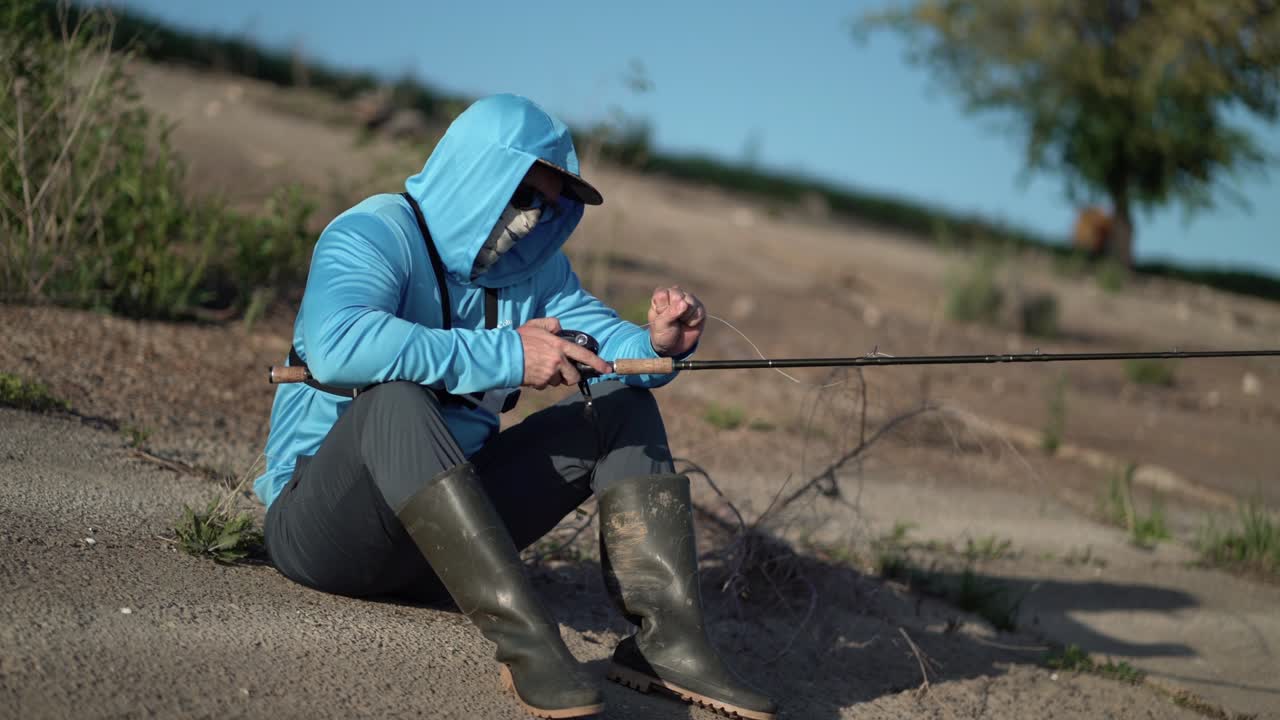 el pescador desenreda la línea de pesca en el carrete para atrapar peces depredadores.