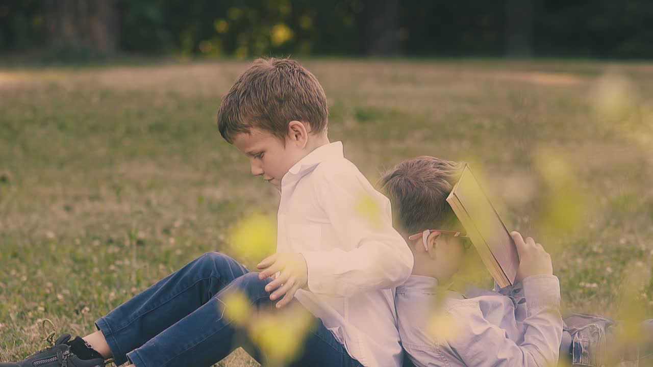 안경을 쓰고 책을 들고 있는 소년 은 반 친구 에게 의지 한다