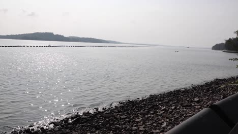 the sea, the shore, the mountain and the gloomy sky in a sunny day