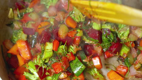 hot steam rising from vegetable pot with broccoli, beetroot, carrots as its being stirred