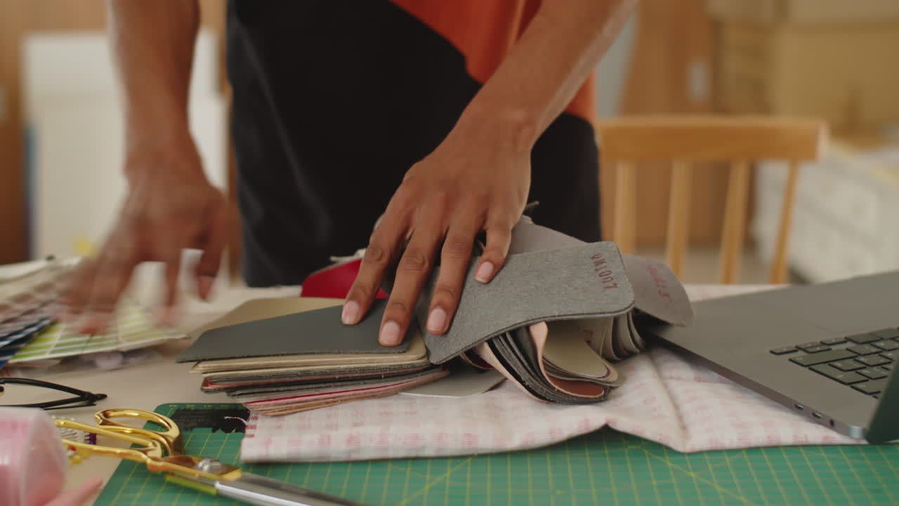 Hands of Seamster Working with Fabric Samples in Atelier