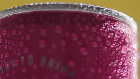 Close-Up-Of-Condensation-Droplets-On-Revolving-Takeaway-Can-Of-Cold-Beer-Or-Soft-Drink-Against-Yellow-Background-3