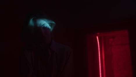 woman in a dark room lit by neon lights