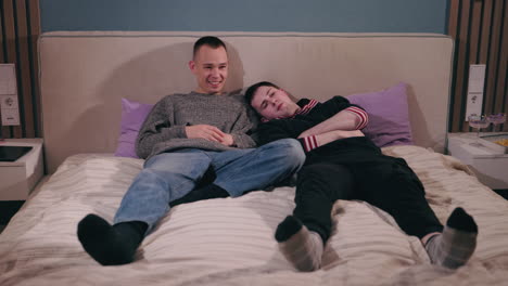 two men relaxing in bed