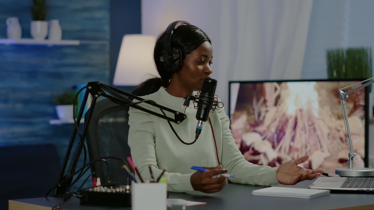Black woman host of online show looking in laptop talking