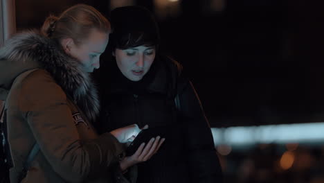 Women-with-digital-tablet-in-evening-street