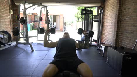 Hombre-Tatuado-En-El-Gimnasio-En-Casa-Prensa-De-Pecho-Inclinada-Con-Mancuernas