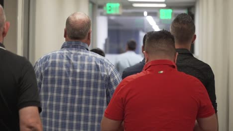 group of men walking down corridoor