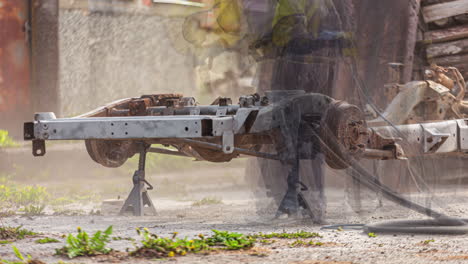 Time-Lapse-of-man-in-protective-suit-sandblasting-part-of-a-car