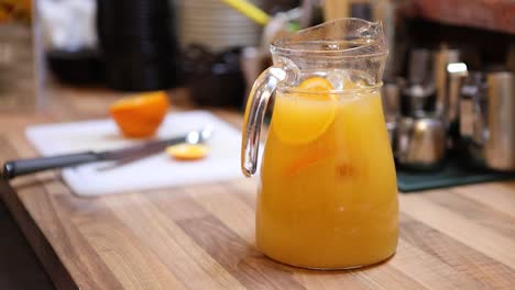 bartender preparing a lemonade in the pitcher my adding syrup and mixing it