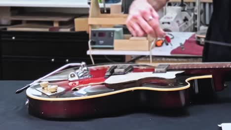 luthier works on acoustic guitar, close up