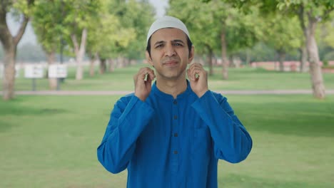 guilty muslim man saying sorry and apologizing in park