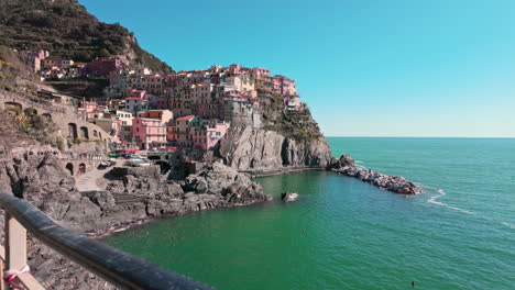colorful buildings at manarola overlooking the turquoise sea, sunny and peaceful