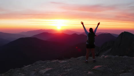 hiker celebrating success on mountain peak at sunset