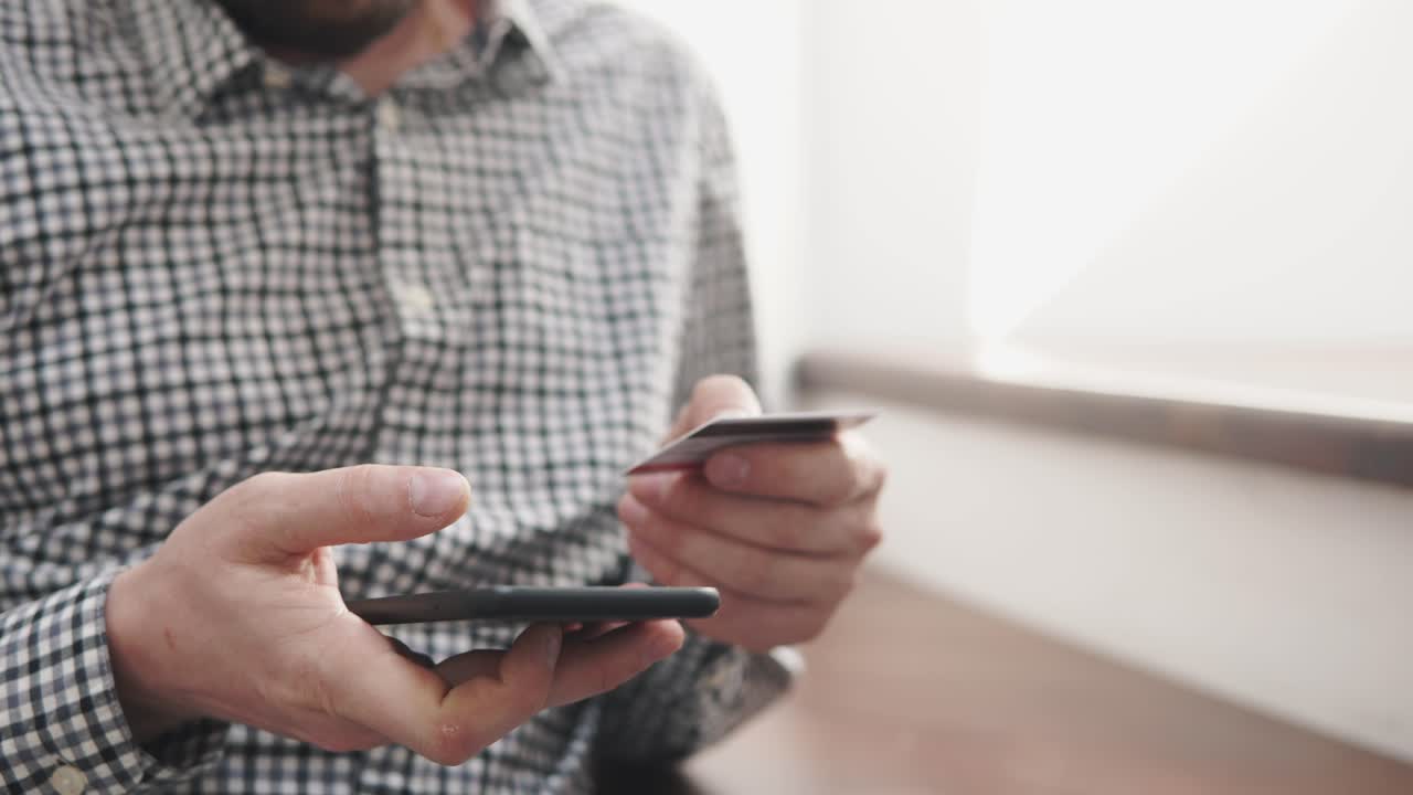 persona que utiliza un teléfono inteligente y una tarjeta de crédito para el pago en línea