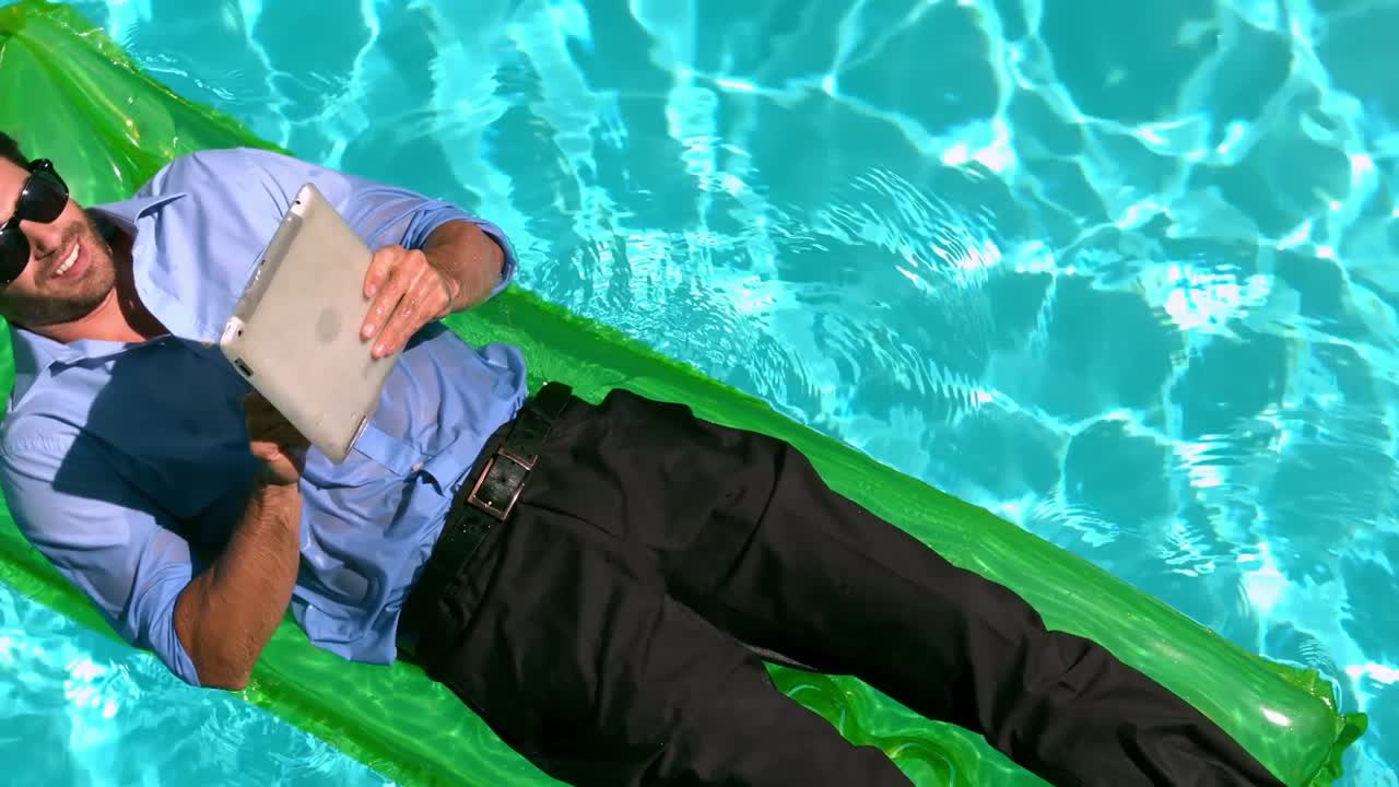 Businessman using tablet on air mattress