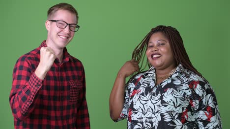 overweight african woman and young scandinavian man together against green background