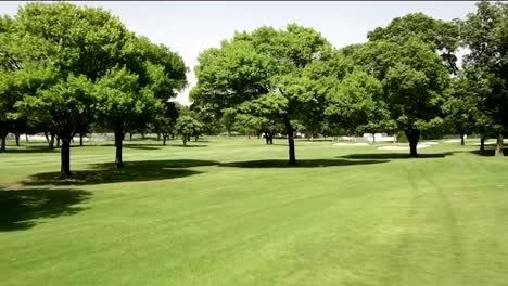 Drone-footage-of-golf-course-fairway-through-trees