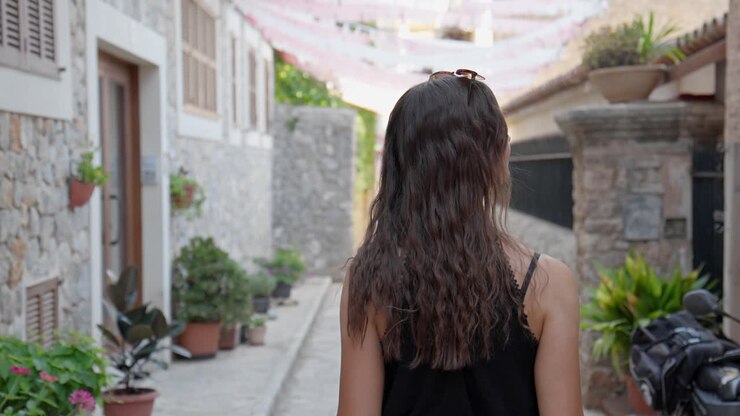 Belle donne che percorrono un marciapiede decorato in una calda giornata di sole a Valldemossa, il villaggio più alto di Maiorca.
