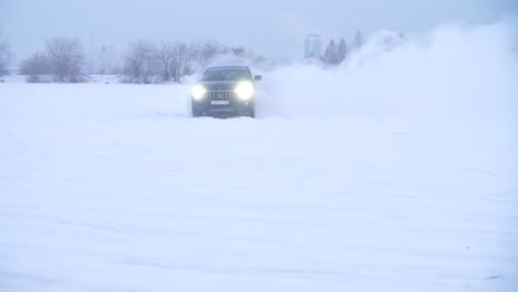 blue suv driving on a snowy field