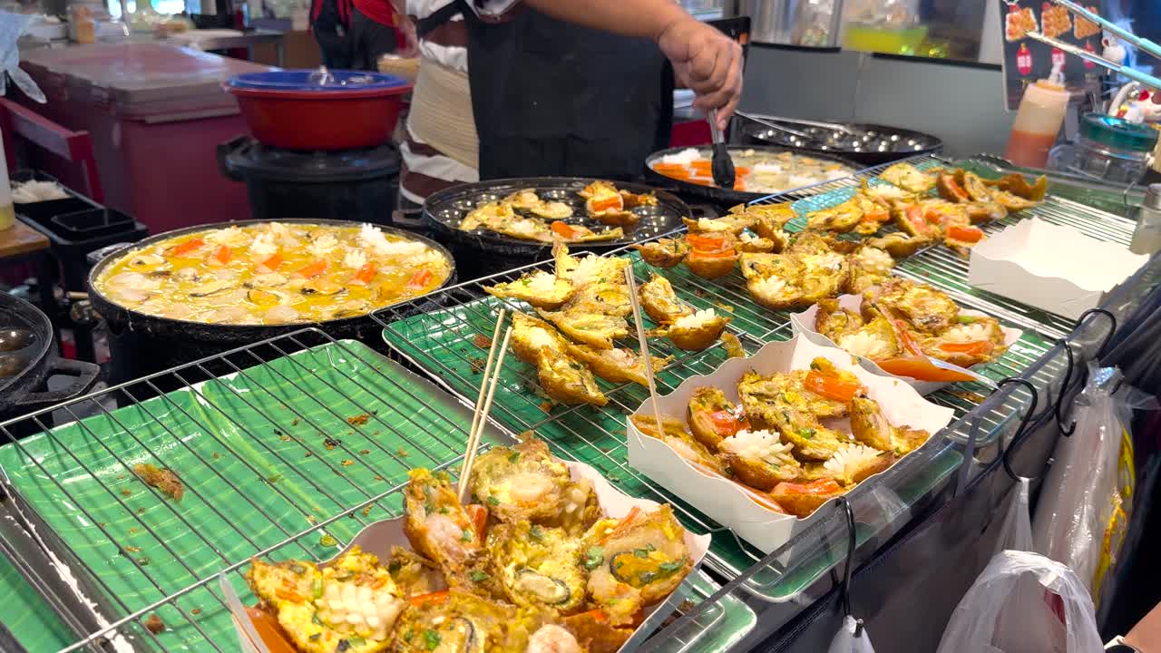 vendedor callejero preparando mariscos en el mercado de bangkok