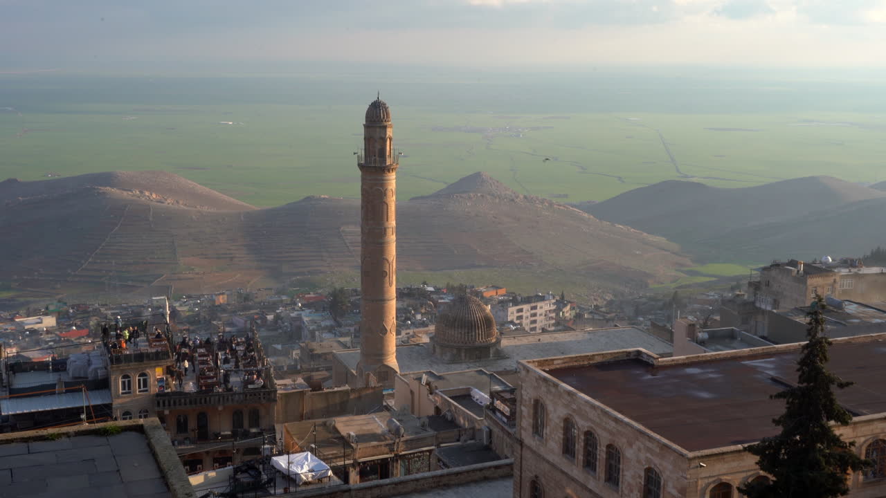 la cámara se está alejando del minarete de ulu camii con vistas a la mezopotemia en un hermoso día soleado